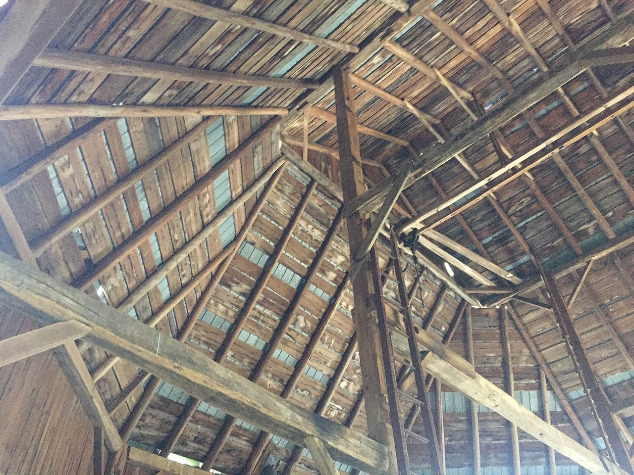 Inside a barn, looking up into the rafters.