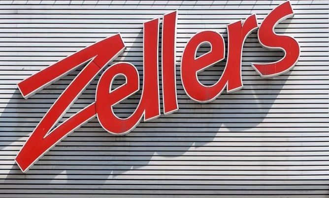 Red Zellers script sign on a wall of white slats.